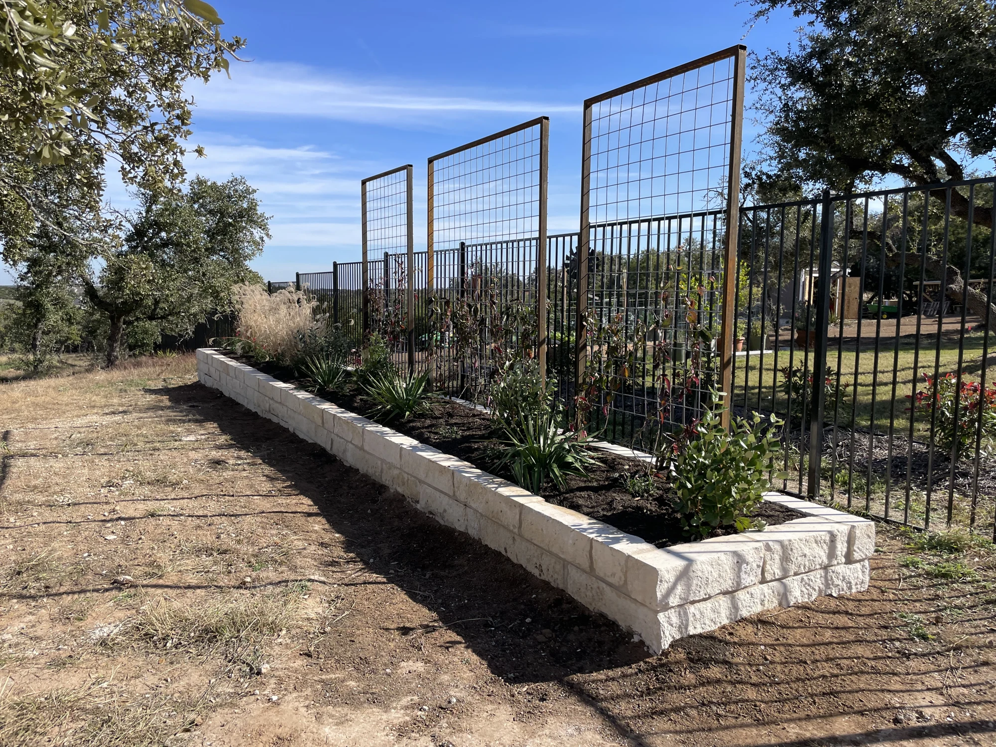 Steel trellis rising above a masoned stone planter